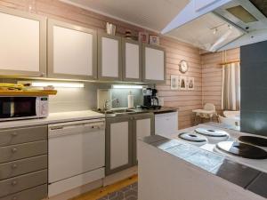 a kitchen with white cabinets and a counter top at Holiday Home Kulta-käkönen 17 by bomba by Interhome in Nurmes