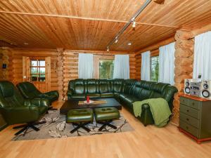 uma sala de estar com um sofá de couro verde e cadeiras em Holiday Home Kolin kuningatar by Interhome em Hattusaari