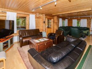 uma sala de estar com um sofá de couro e uma televisão de ecrã plano em Holiday Home Kolin kuningatar by Interhome em Hattusaari