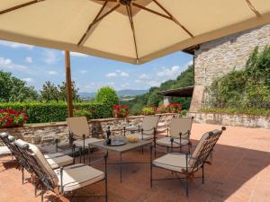 a patio with a table and chairs under an umbrella at Holiday Home La Terrazza by Interhome in Vicchio