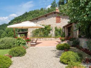 an umbrella in front of a stone building at Holiday Home La Terrazza by Interhome in Vicchio