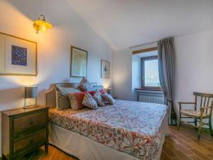 sypialnia z łóżkiem, krzesłem i oknem w obiekcie Apartment Trilocale Casa nel Castello by Interhome w mieście Casale Marittimo