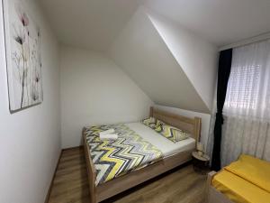 une petite chambre avec un lit dans un grenier dans l'établissement Apartman Vucinic, à Cetinje
