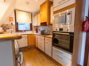 a kitchen with a microwave and a stove top oven at Chalet Glen Muir Lodge by Interhome in Spean Bridge