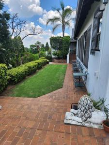 a brick patio with a bench on a house at Aleia Cottage in Pretoria