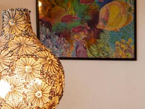 un jarrón de oro sentado al lado de una pintura en una pared en Apartment I-1-8 by Interhome, en Golfo Aranci