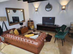 salon z brązową skórzaną kanapą i lustrem w obiekcie Aleia Cottage w mieście Pretoria