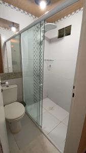 a bathroom with a toilet and a glass shower at Apartamento Charme Guará in Guaramiranga
