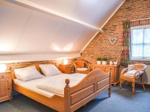 a bedroom with a bed and a brick wall at Holiday Home De Bron by Interhome in Losser