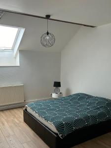 Spacieux duplex à Folschviller : غرفة نوم مع سرير في غرفة مع نافذة