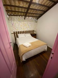 a bedroom with a bed and a pink door at Apartamento Charme Guará in Guaramiranga