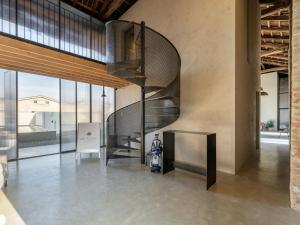 una escalera de caracol en el vestíbulo con una moto en Villa We Rural by Interhome, en Poirino