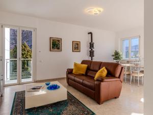 sala de estar con sofá marrón y mesa en Villa Betulla-3 by Interhome, en Dervio