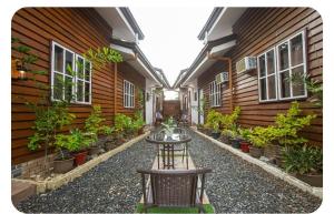 un patio de un edificio con una mesa y macetas en Barn Hostel en Panglao City