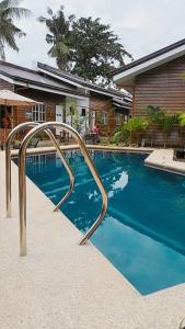 a swimming pool with a metal rail next to a house at Barn Hostel in Panglao