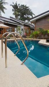 a swimming pool with a metal rail next to a house at Barn Hostel in Panglao Island