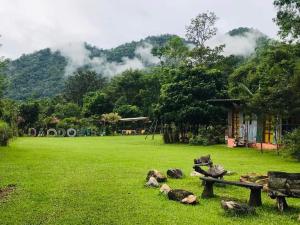 a park with a bench and rocks in the grass at Dawdoylisu Chiangmai in Ban Ton Kham