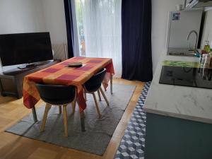 a kitchen with a wooden table and two chairs at Paris/La Défense 10' en train 2 CHB in Colombes