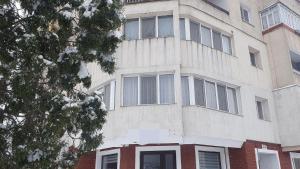un edificio alto con ventanas laterales en Apartament AKM, en Târgu Ocna