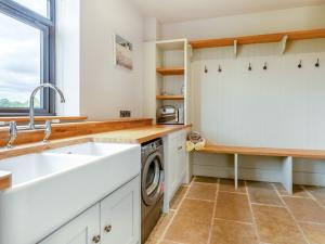 a kitchen with a sink and a washing machine at 5 Bed in Shrewsbury 80686 in Llanymynech