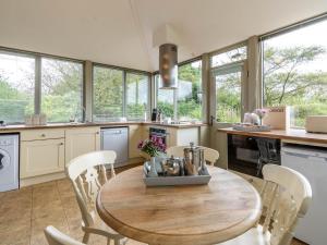 a kitchen with a wooden table and chairs and windows at 2 Bed in Scarborough 79521 in Sawdon