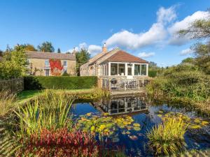 a house with a pond in front of it at 2 Bed in Scarborough 79521 in Sawdon