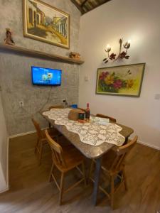 a dining room with a table and chairs at Apartamento Charme Guará - Na Praça de Guaramiranga in Guaramiranga