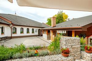 Casa con pared de piedra y patio en Kostel Panzió, en Kesztölc