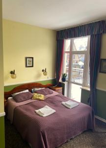 Un dormitorio con una cama con sábanas moradas y una ventana en Tuberoza, en Zakopane