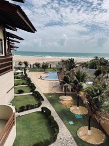 a view of a resort with a swimming pool and the beach at Apartamento de Frente para o Mar na praia da Taiba Ceará in Taíba