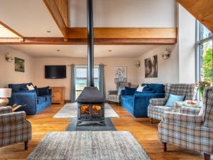 a living room with a fireplace and blue couches at 5 Bed in Garth BN162 in Garth