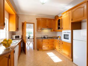 - une cuisine avec des placards en bois et des appareils blancs dans l'établissement Villa Jardin d'Eden by Interhome, à Albufeira