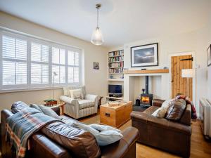 a living room with two leather couches and a fireplace at 3 Bed in Craster 79436 in Craster