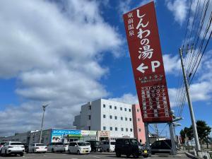 a sign in front of a parking lot with cars at HigashimaeOnsen Shinwanoyu Hotel Akitaya in Hokuto