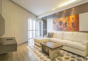 a living room with a couch and a table at HomesGetaway- Lovely 1BR in Hyatt Regency Creek Heights Residences in Dubai