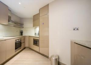 a large kitchen with white walls and stainless steel appliances at HomesGetaway- Lovely 1BR in Hyatt Regency Creek Heights Residences in Dubai