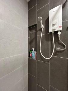 y baño alicatado con ducha y secador de pelo. en IOI City Mall Modern Home PICC, en Putrajaya