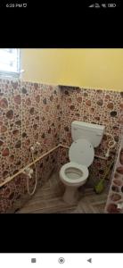 ein Bad mit einem WC und einer Mosaikwand in der Unterkunft Royal home homestay in kolkata