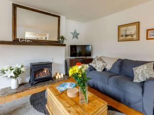 a living room with a blue couch and a fireplace at 3 Bed in Bideford 79552 in Bideford