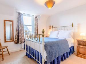 a bedroom with a bed with a blue and white bedspread at 2 Bed in Alnmouth 81280 in Alnmouth