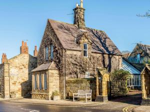 an old stone building with a bench in front of it at 2 Bed in Alnmouth 81280 in Alnmouth