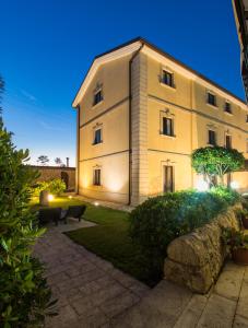 a large white building with a garden in front of it at Antica Stazione in Chiaramonte Gulfi