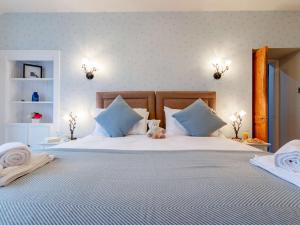 una gran cama blanca con un osito de peluche sentado en ella en 2 Bed in St Andrews 81388, en Errol