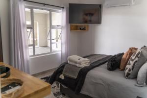 Schlafzimmer mit einem Bett und einem Fenster mit Handtüchern in der Unterkunft Waterfront Boutique Hotel Vanderkloof in Vanderkloof
