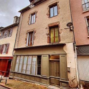 een oud gebouw met dichtgetimmerde ramen en een deur bij T2entièrement rénové style industriel in Rodez