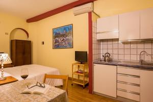 um quarto com uma cozinha com uma mesa e uma cozinha gmaxwell gmaxwell gmaxwell em Bollo Apartments em Roma