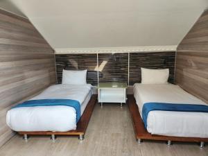 - 2 lits dans une petite chambre avec une table dans l'établissement Gem of Manor drive, à Durban