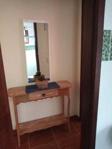 a dressing table with a mirror and a plant on it at Casa da Lu in Macaé