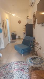 uma sala de estar com um sofá azul e um tapete em נקודות ריפוי em Tirat Karmel