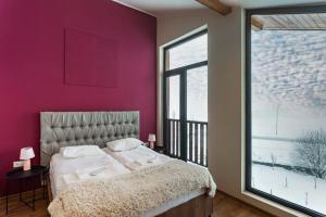 古道里的住宿－Chalet In Gudauri，一间卧室配有一张床和紫色的墙壁